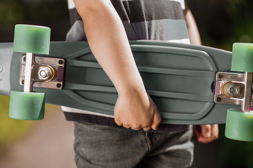 Skateboard. Close up picture of a kids hand holding a skateboard