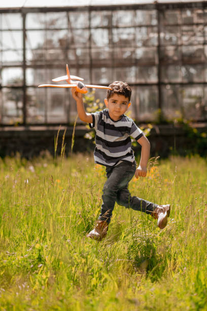 istock Cute boy with a toy plane looking playful 1445465127