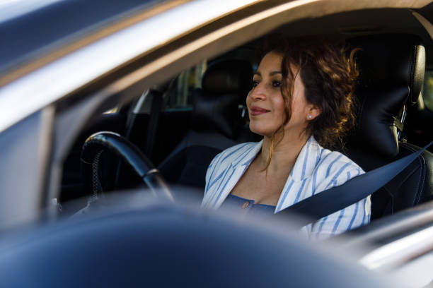 istock Charming mid adult woman sitting in her car and driving 1445465708