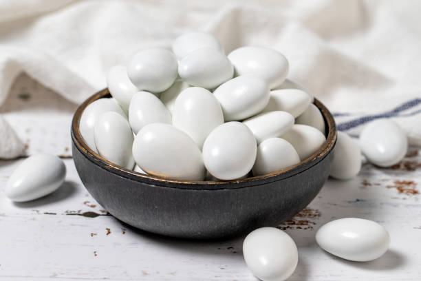 istock White chocolate dragee. Chocolate dragee on a white wood background. close up 1445466276
