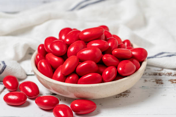 istock Red chocolate dragee. Chocolate dragee on a white wood background. close up 1445466368