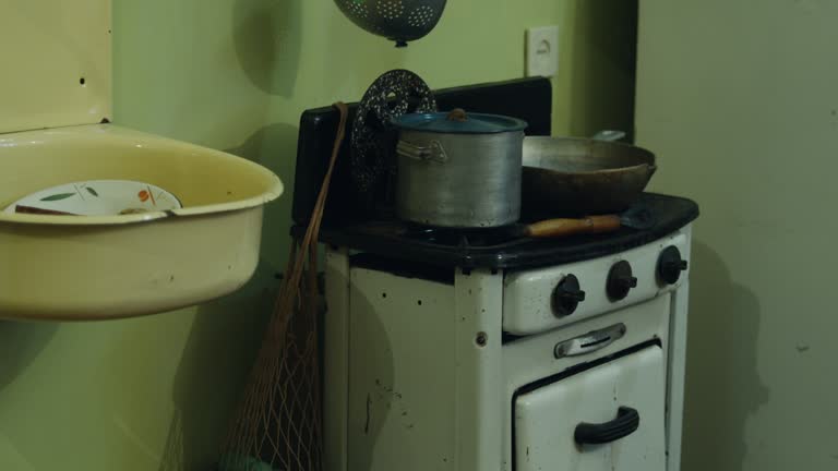 An old washbasin with a gas stove and pans standing on the burners.