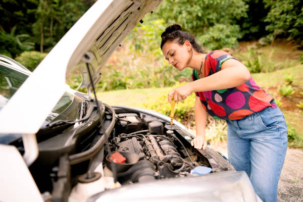 istock Young woman checking car oil 1445475780