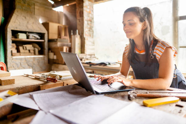 istock Woman carpenter working on laptop in carpentry workshop 1445475819