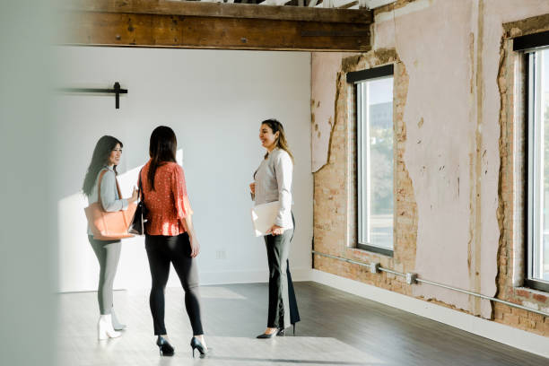 istock Three businesswomen discuss loft office space 1445481764