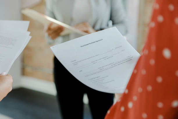 istock Unrecognizable woman holds purchase agreement paperwork for rental 1445481975