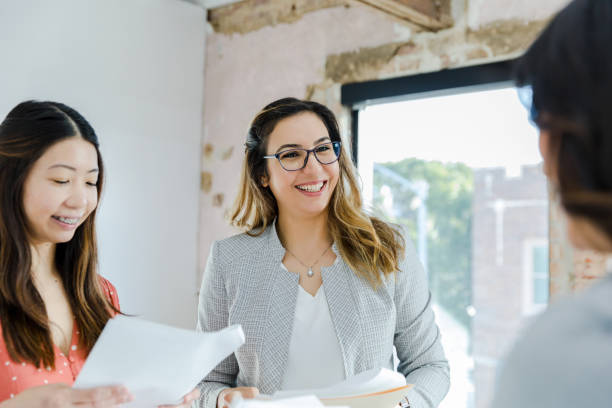 istock Three cheerful businesswomen discuss paperwork 1445483494