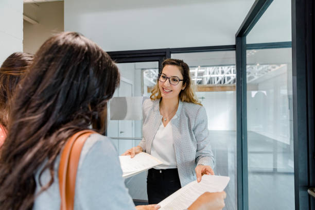 istock Real estate agent explains purchase documents for property to businesswomen 1445483783