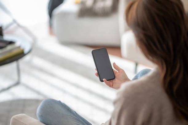 istock ong haired woman holding a blank screen cellphone in her hand 1445483797