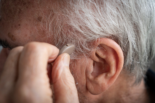Elderly Man Inserting His Hearing Aid