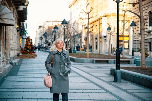 Woman tourist walking in the city downtown, enjoying in winter day on the street. Copy space
