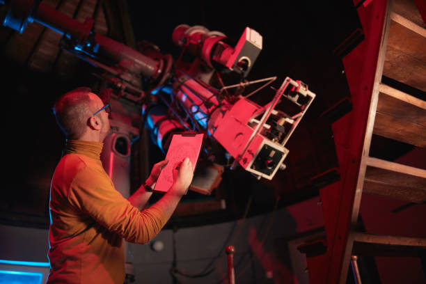 istock Astronomer with a big astronomical telescope in observatory doing science research of space and celestial objects. 1445488865