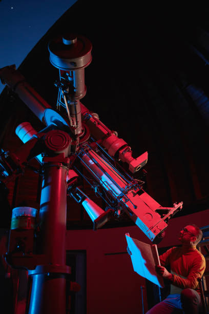 istock Astronomer with a big astronomical telescope in observatory doing science research of space and celestial objects. 1445488924