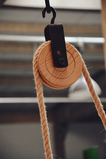 Pulley and rope on old sailing ship. Sailing boat pulley with nautical rope. Old Style Wooden Pulley With Rope