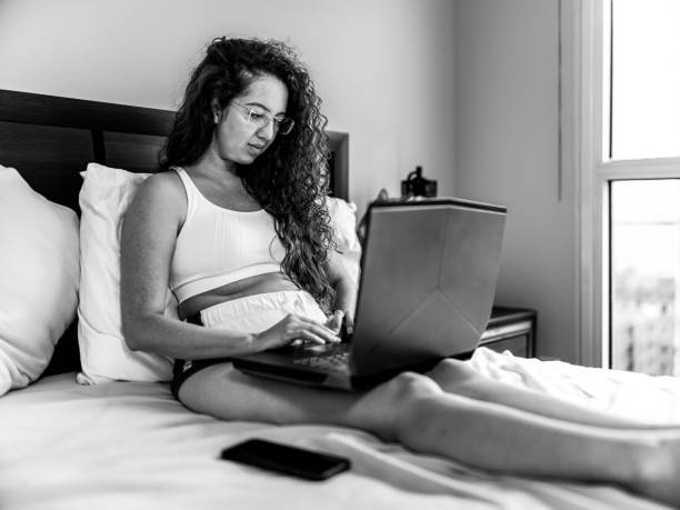 istock Young mixed race woman working on lap top  in her bedroom 1445491561