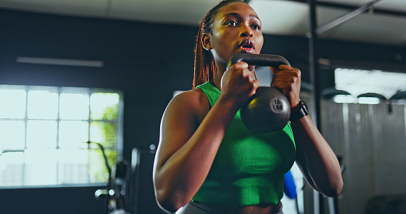 Exercise, kettlebell and black woman in gym, for fitness and workout for wellness, health and training. Healthy girl, African American female and athlete with equipment for practice, cardio or strong