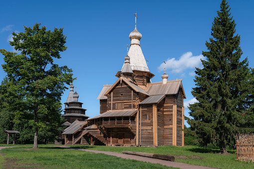 View of the Church of the Assumption of the Virgin and the Church of St. Nicholas in the Novgorod Museum of Folk Wooden Architecture of Vitoslavlitsa on a sunny summer day, Veliky Novgorod, Russia