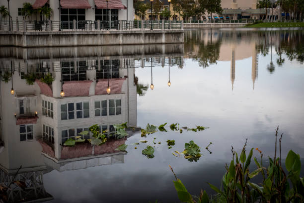 A building reflects in the adjacent pond in the downtown area of the small town of Celebration, Florida on an overcast and rainy day.