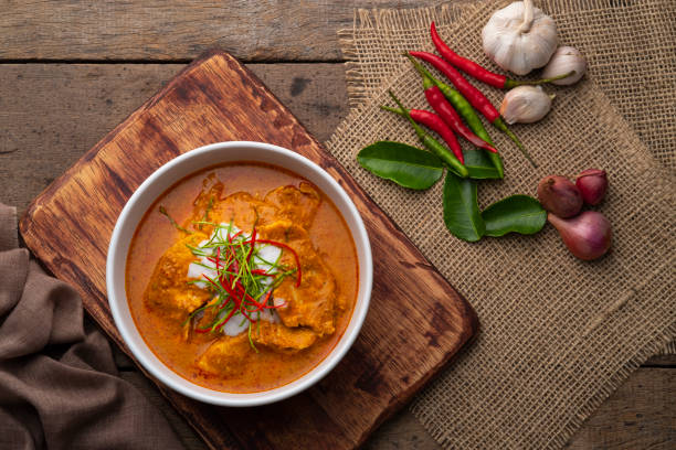 panaeng curry with chicken.sliced chicken breast meat in red curry paste and coconut milk,topping with coconut cream and shredded kaffir lime leaves.thai style food - panang curry imagens e fotografias de stock