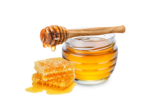 Honey isolated on white background. Jar with honey, honeycomb and honey dipper with drop of honey.