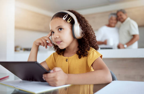 istock Children, tablet and education with a girl thinking while distance learning using headphones for home school. Idea, study and technology with a female student in her grandparents house to learn 1445504509