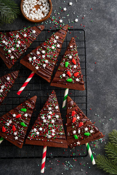 istock Chocolate brownies Christmas tree with chocolate icing and festive sprinkles on stone table. Christmas food ideas sweet homemade Christmas holidays pastry concept. Holiday cooking concept. Top view. 1445504809