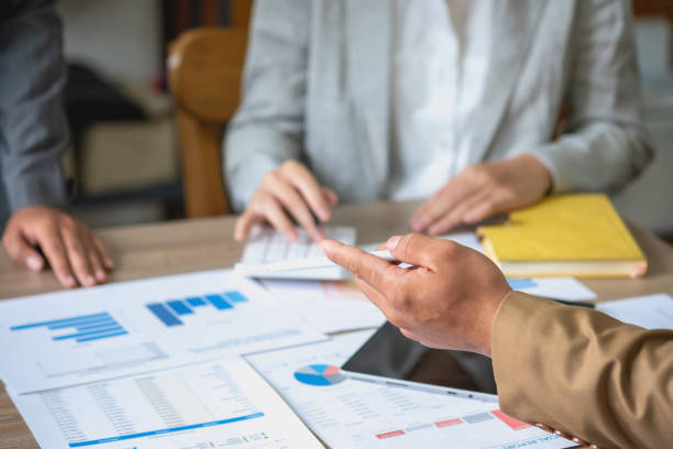 istock Team of business use calculators and graph analysis computer laptop tablets to plan marketing strategies and make profitable investments for the company. 1445505070