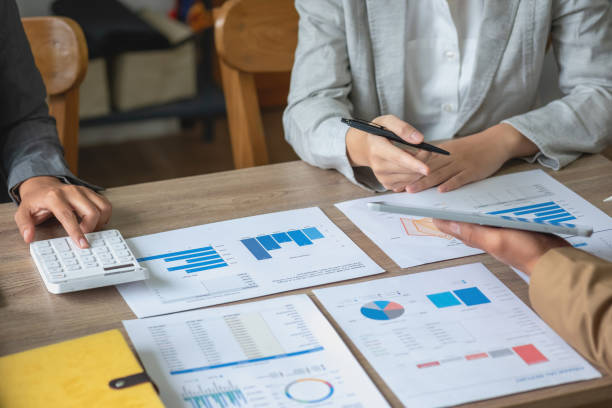 istock Team of business use calculators and graph analysis computer laptop tablets to plan marketing strategies and make profitable investments for the company. 1445505308
