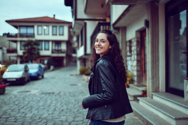 Smiling Female Strolling Through Old City At Dusk