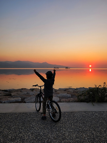 litlle boy riding a bike by the sea
