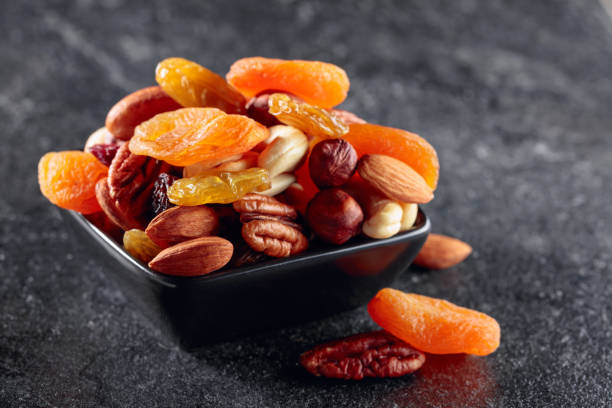 istock Dried fruits and nuts on a black stone table. 1445507303