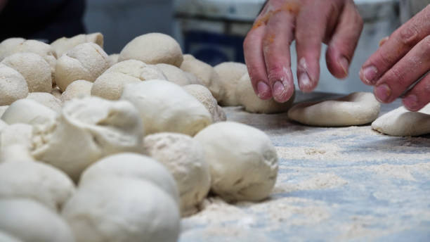 istock male chef in the kitchen is preparing dough balls with his hands 1445507667