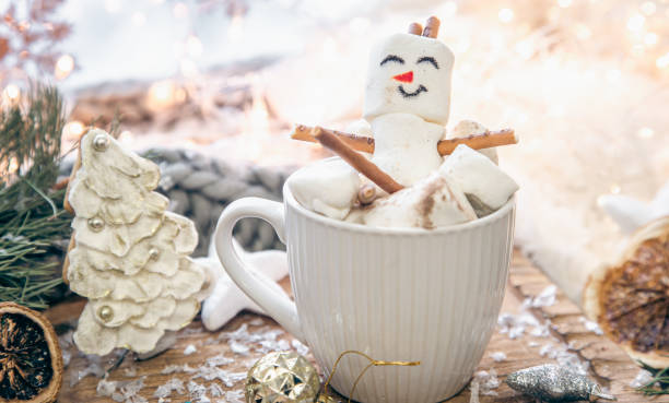 istock Christmas background with marshmallow snowman in a cup. 1445509202