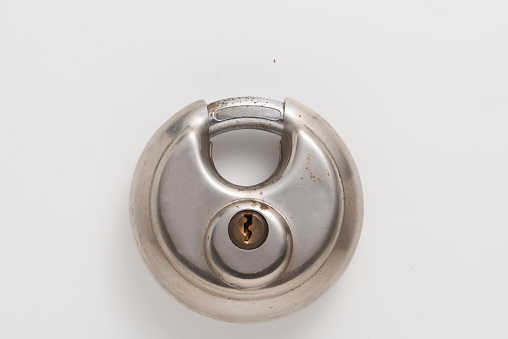 A close up image of the key hole on an old weather worn metal door knob.