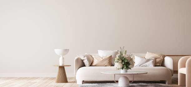 Bright modern living room mockup, beige sofa with marble coffee table and flower vase on white background, panorama stock photo