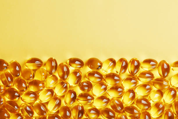 istock Capsules in a shell with liquid vitamin D3 on a yellow background and a place for text 1445514280