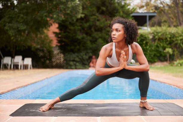 istock Afro-Latina female  instructor outdoors getting into the  Side Lunge prayer pose 1445516610