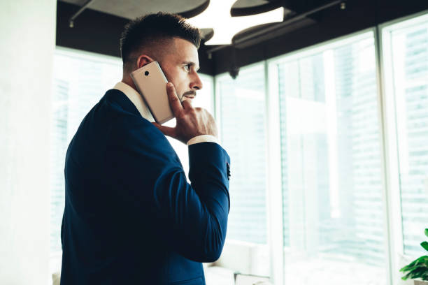 istock Successful male executive in suit talking on smartphone at office 1445520152