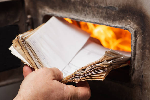 Man loads old paper in the solid fuel boiler
