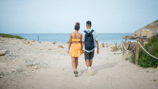 istock Loving african ethnicity couple holding each other. Romantic walk on a sunny beach 1445522749