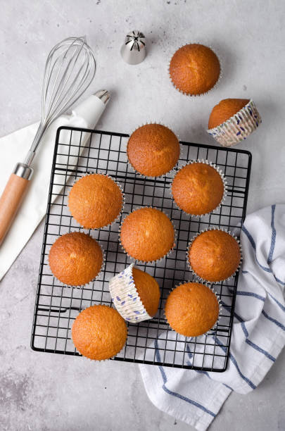 istock Vanilla cupcakes on a baking rack and decoration for cupcakes with frosting in a pastry bag 1445524295