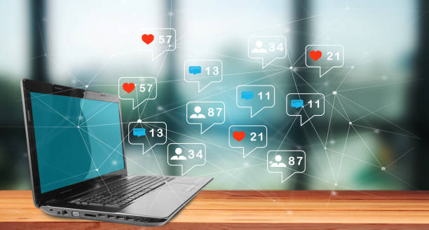 istock Social media notification icon from the web. Laptop on wooden table 1445528162