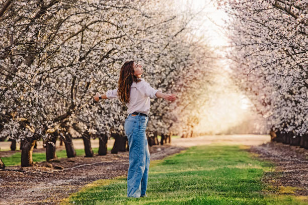 istock Woman enjoying springtime outdoors among blooming almond trees 1445531539