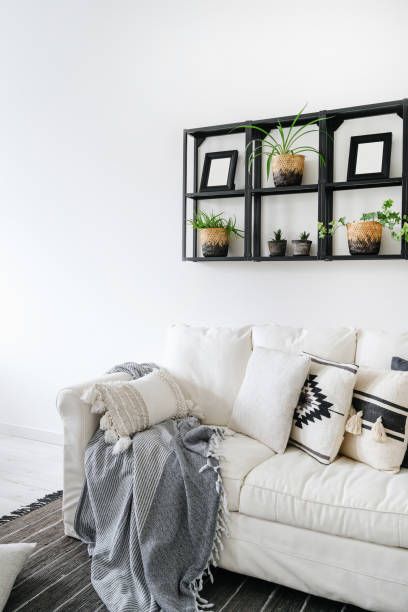 istock Room with home decor on wall shelf over couch, cushions and plaid 1445531576