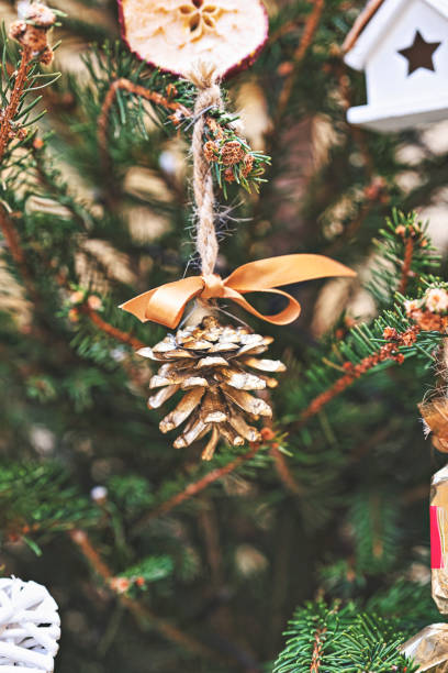 istock Christmas tree is decorated with natural pine tree cone painted in gold. Handmade Christmas decorations zero-waste and no plastic 1445532393