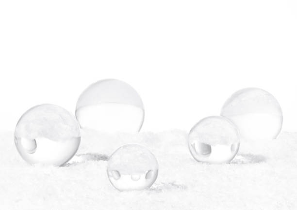 Transparent glass orbs with white snow on isolated white background. Christmas decorations concept. Copy space.