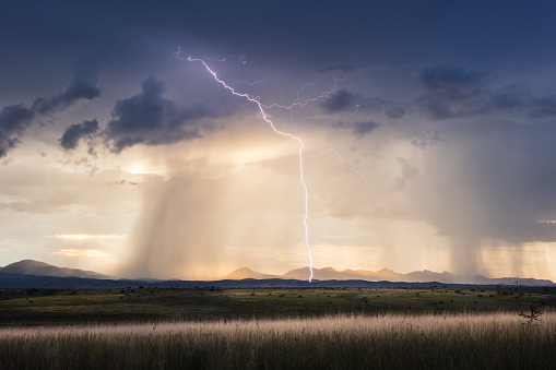 Stormy sky with dramatic clouds, lightning and golden sunlight near Sonoita, Arizona.