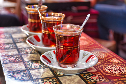 close up of three tea glasses of traditional turkish tea and spoon on backgammon table