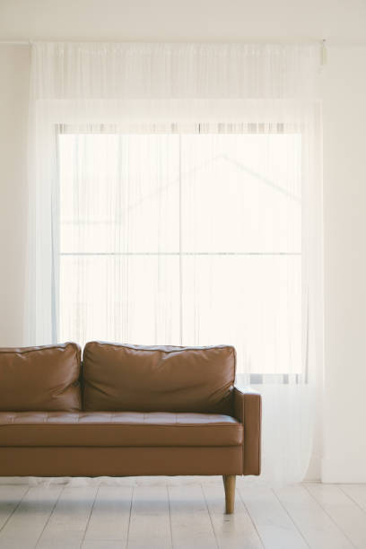 istock Minimal decor in home with leather couch and big windows with na 1445546183