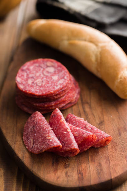 Sliced mexican salami with beans on cutting board. Sliced mexican salami with beans on the cutting board. sliced salami stock pictures, royalty-free photos & images